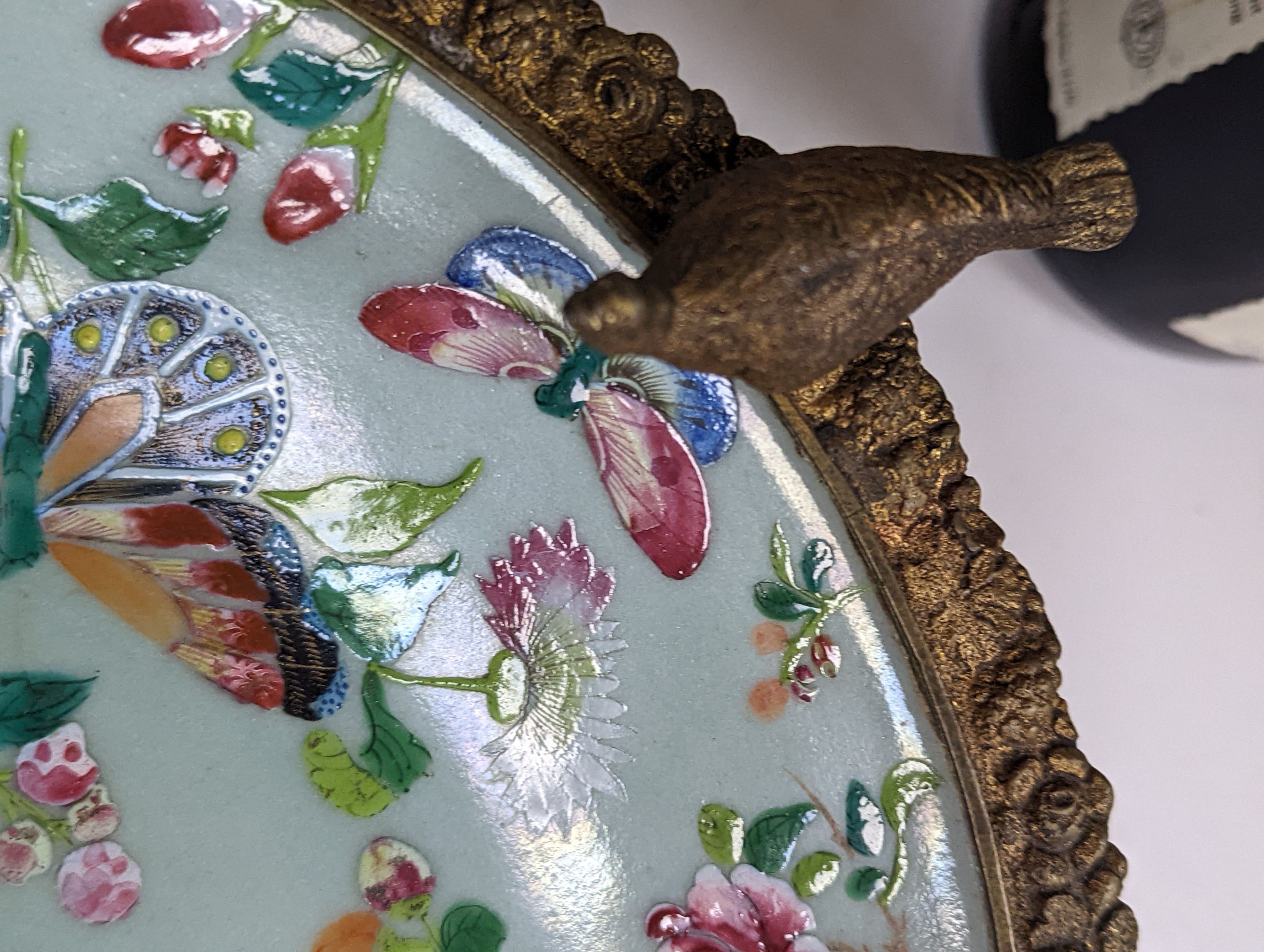 A 19th century Chinese famille rose dish with ormolu mount, 29 cms diameter.